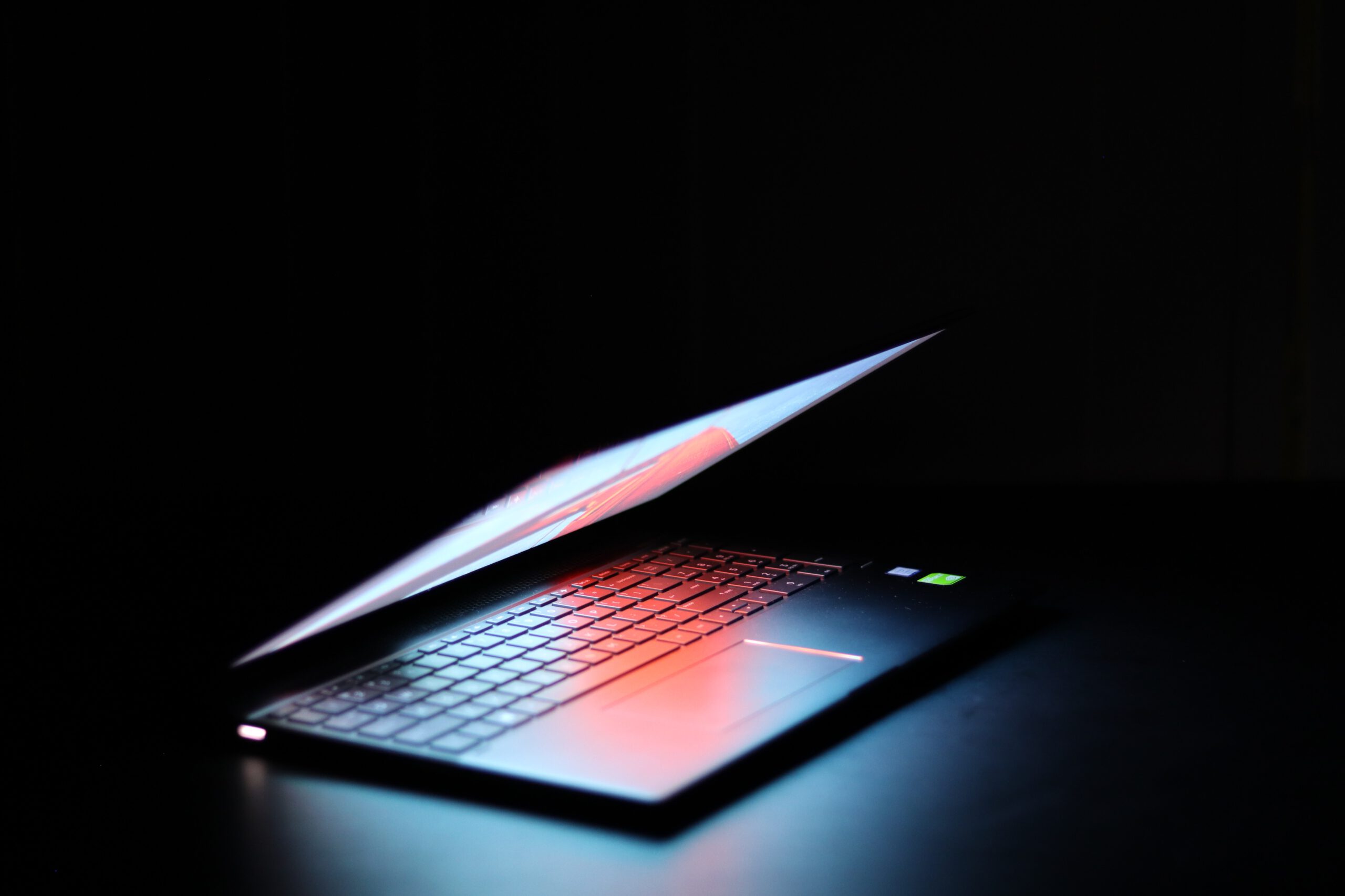 KI_Park Ein Laptop mit Fähigkeiten zur Künstlichen Intelligenz leuchtet im Dunkeln.